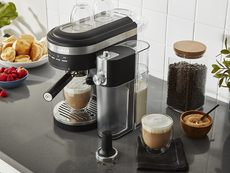 Latte in black KitchenAid® Espresso Machine with Automatic Milk Frother Attachment on counter with ingredients
