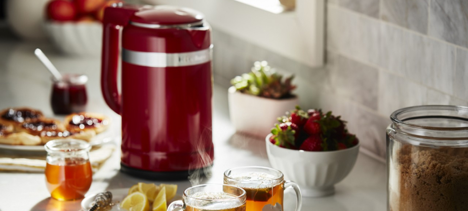 Empire Red KitchenAid® electric kettle next to tea cups on a counter