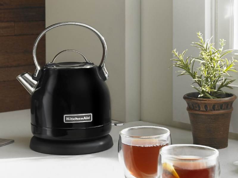 KitchenAid® electric kettle on a kitchen counter next to cups of fresh brewed tea