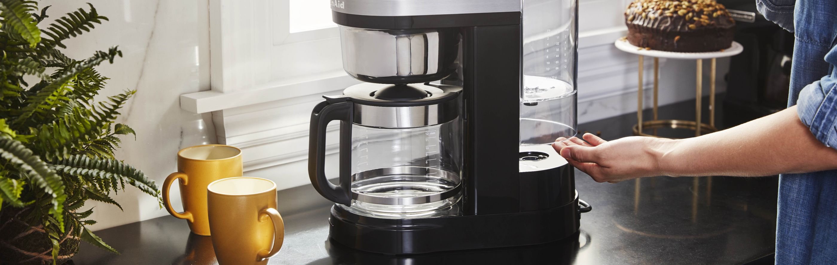 Woman removing water tank from KitchenAid® drip coffee maker