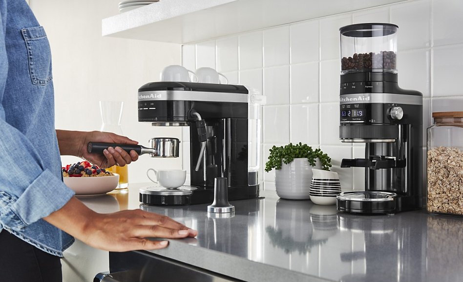 Woman making espresso in bright kitchen