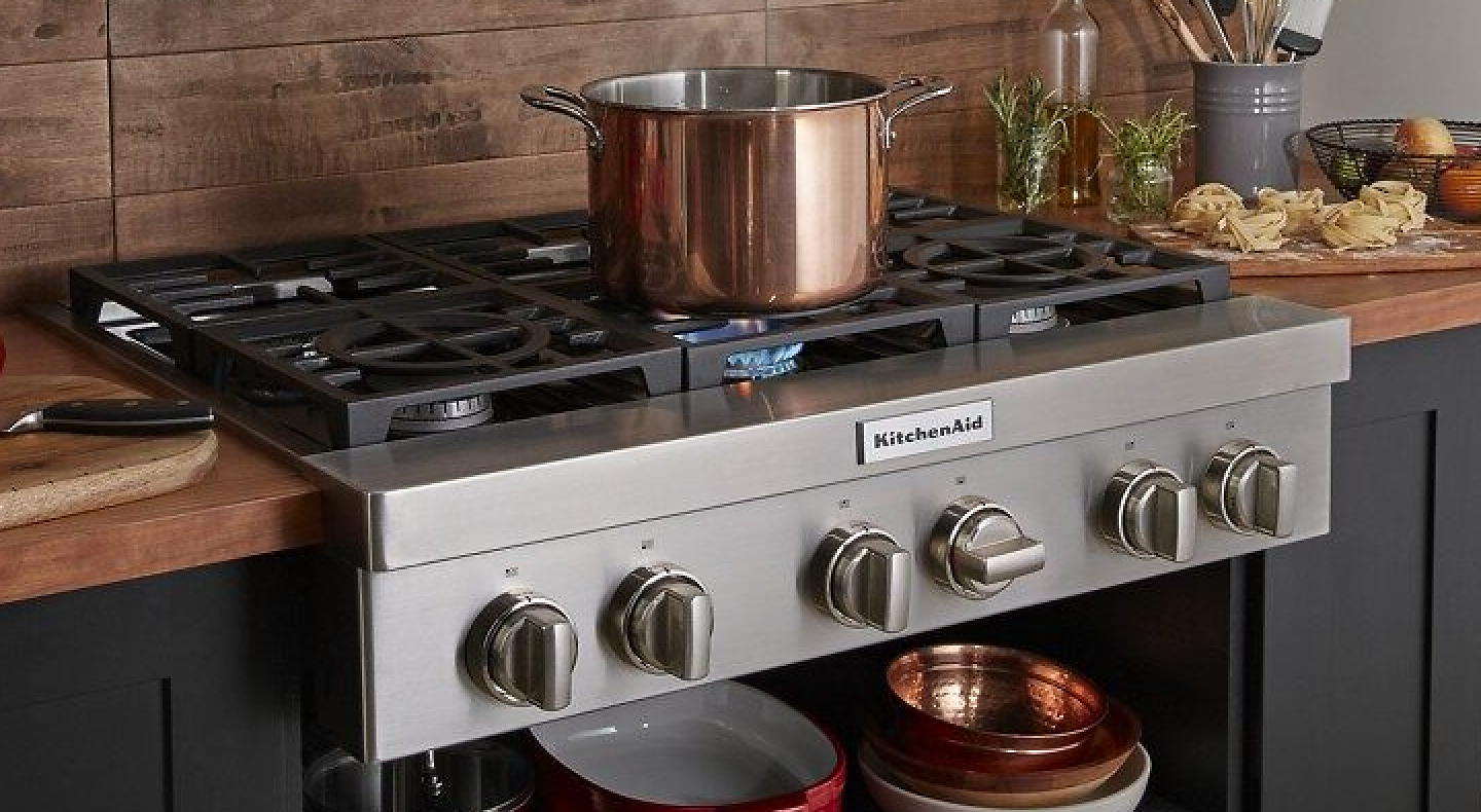 A large pot sitting on an activated KitchenAid® stovetop burner