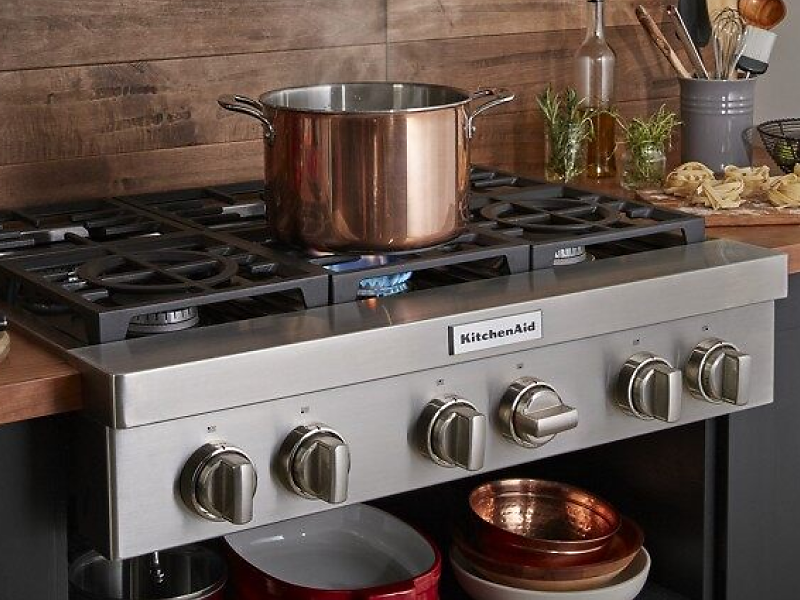A large pot sitting on an activated KitchenAid® stovetop burner
