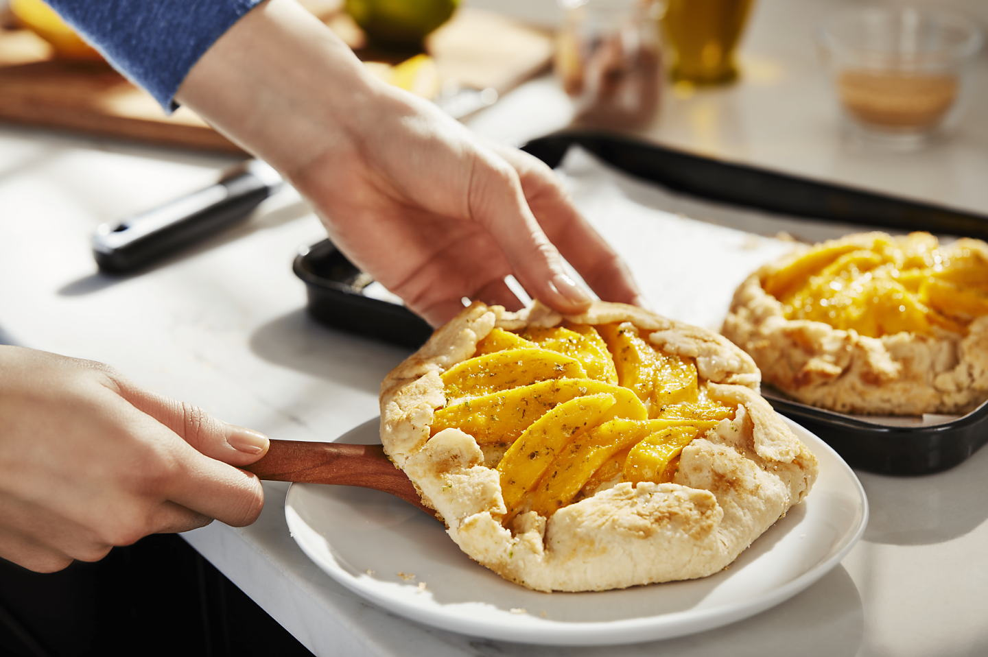 Hands placing homemade apple galette on a plate