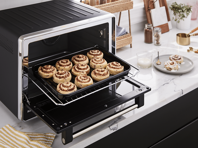 Baking tray of cinnamon rolls inside a countertop oven