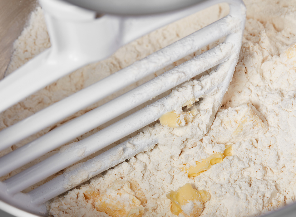 Up close view of pastry blender mixing flour and butter in stand mixer