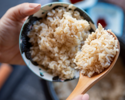 Person scooping rice into a bowl