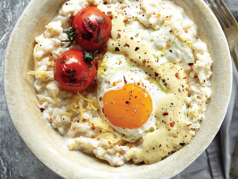 Risotto topped with grape tomatoes and a fried egg