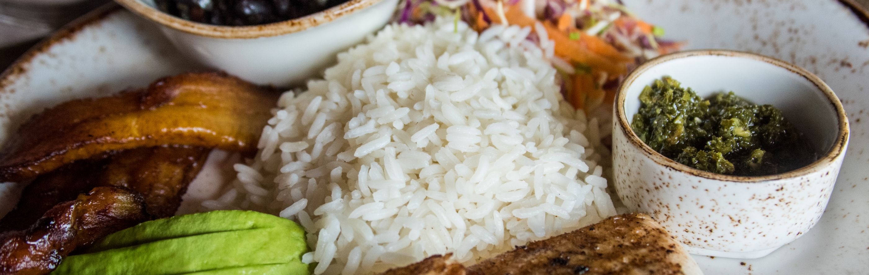White rice on a place with sauces, vegetables and meat