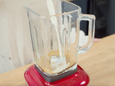 Milk pouring into a red KItchenAid® blender
