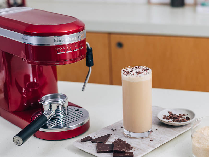 Frappe topped with chocolate shavings next to a KitchenAid® espresso machine