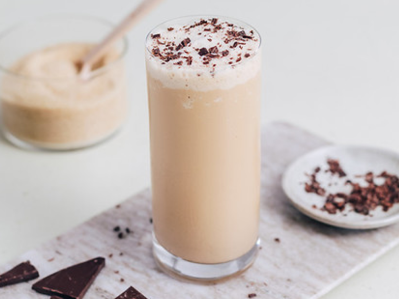Frappe in a tall glass topped with fresh chocolate shavings