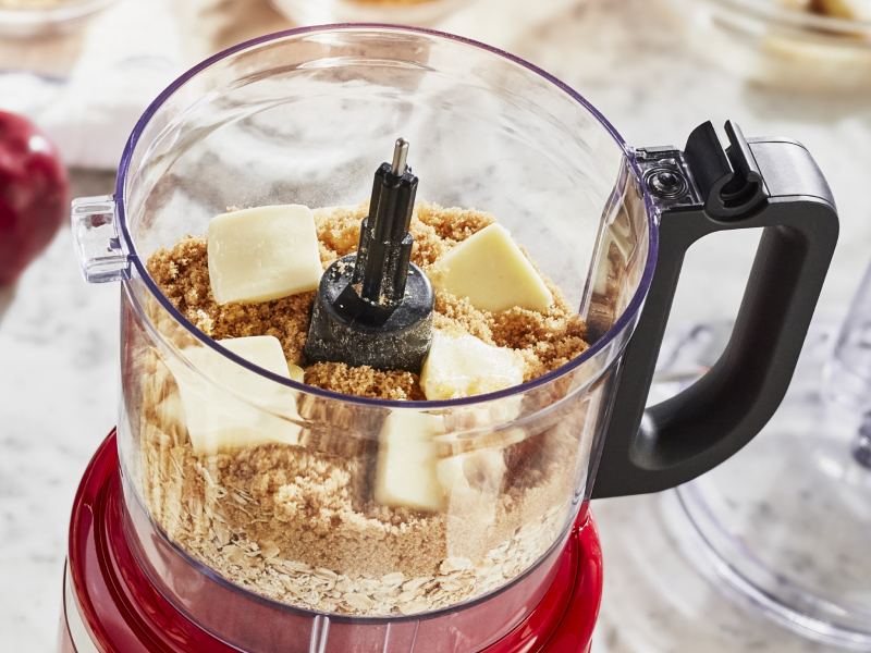 Crushed graham crackers and cubes of butter in a KitchenAid® food processor