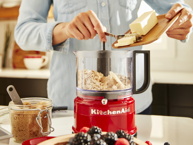 Person adding butter to a KitchenAid® food processor