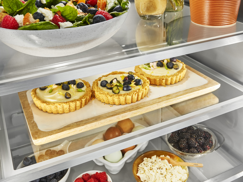 Three custard tarts topped with fruit inside a KitchenAid® refrigerator