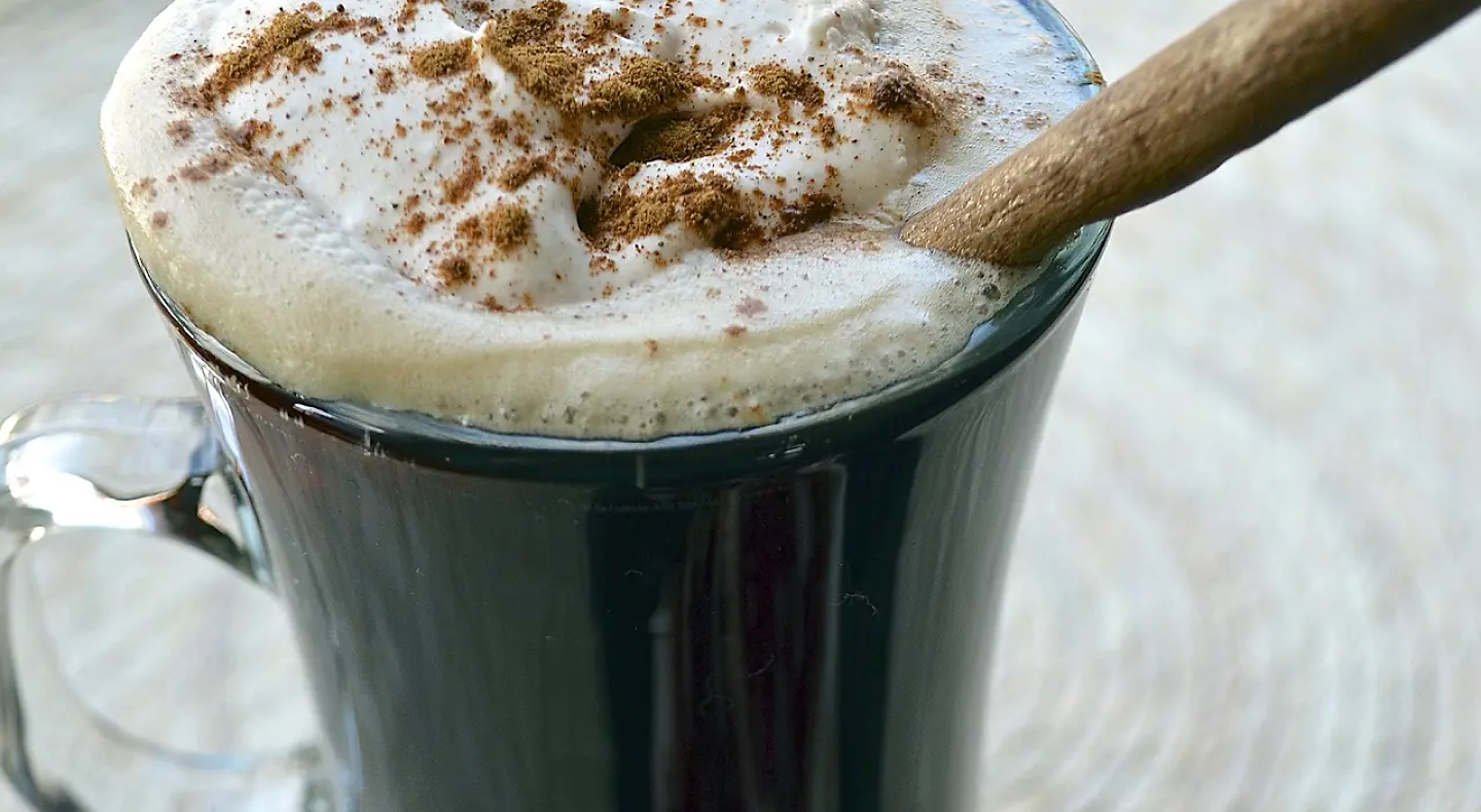 Hot Irish coffee topped with whipped cream and cinnamon