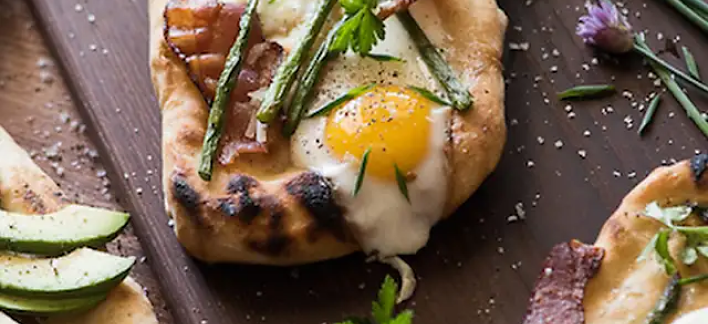 Brunch pizza topped with fried eggs and asparagus