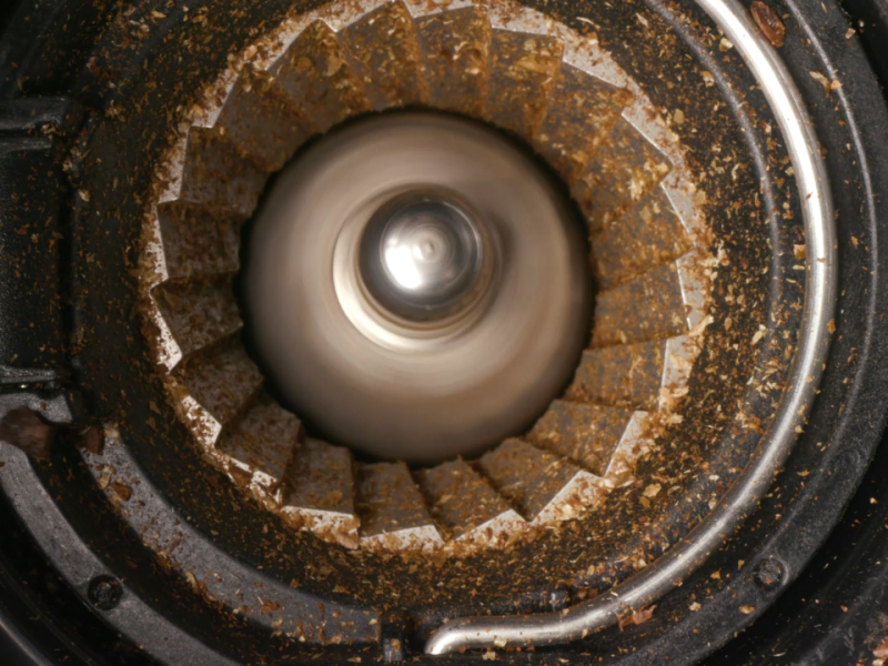 Close up image of a burr grinder grinding coffee beans