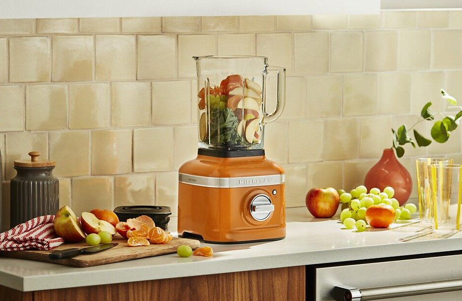 Fruits and veggies in a Honey orange KitchenAid® Blender for baby food