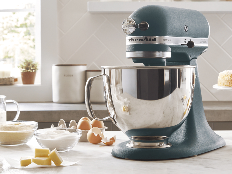 KitchenAid® stand mixer in a modern kitchen next to egg shells, butter, sugar and flour. 
