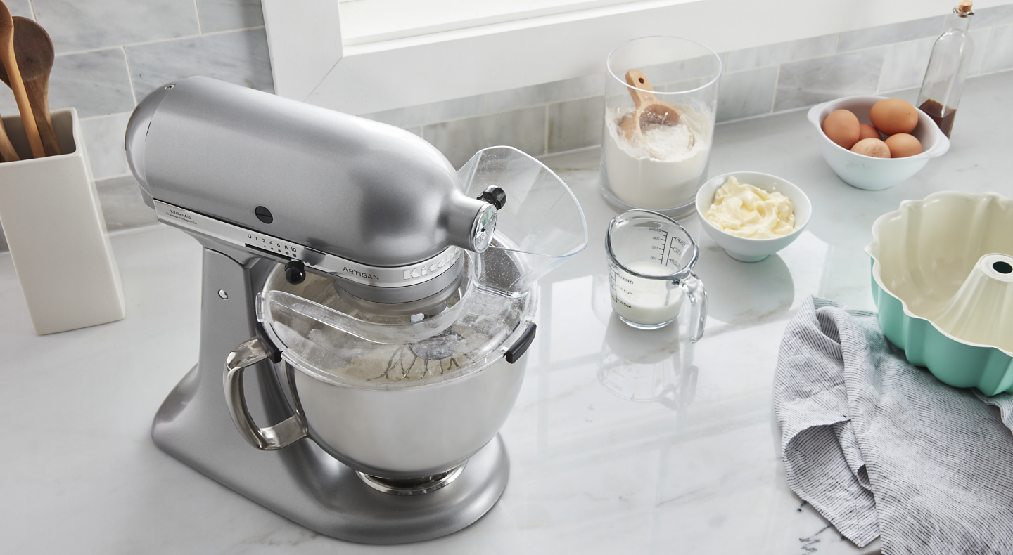 Stainless steel stand mixer next to to cake batter ingredients