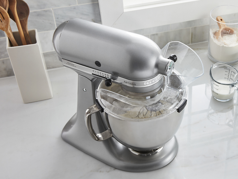 Stainless steel stand mixer next to to cake batter ingredients