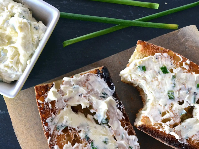 Toasted baguette with herb butter spread on it