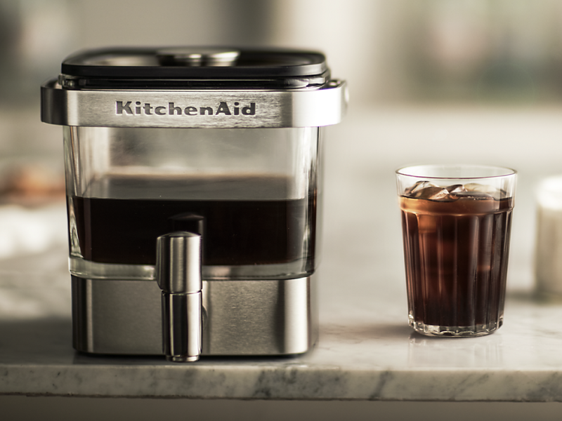 KitchenAid® cold brew coffee maker next to a glass