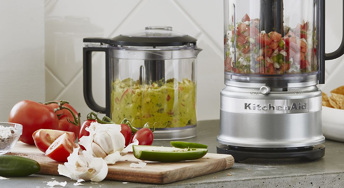 Guacamole and salsa in food processors on counter