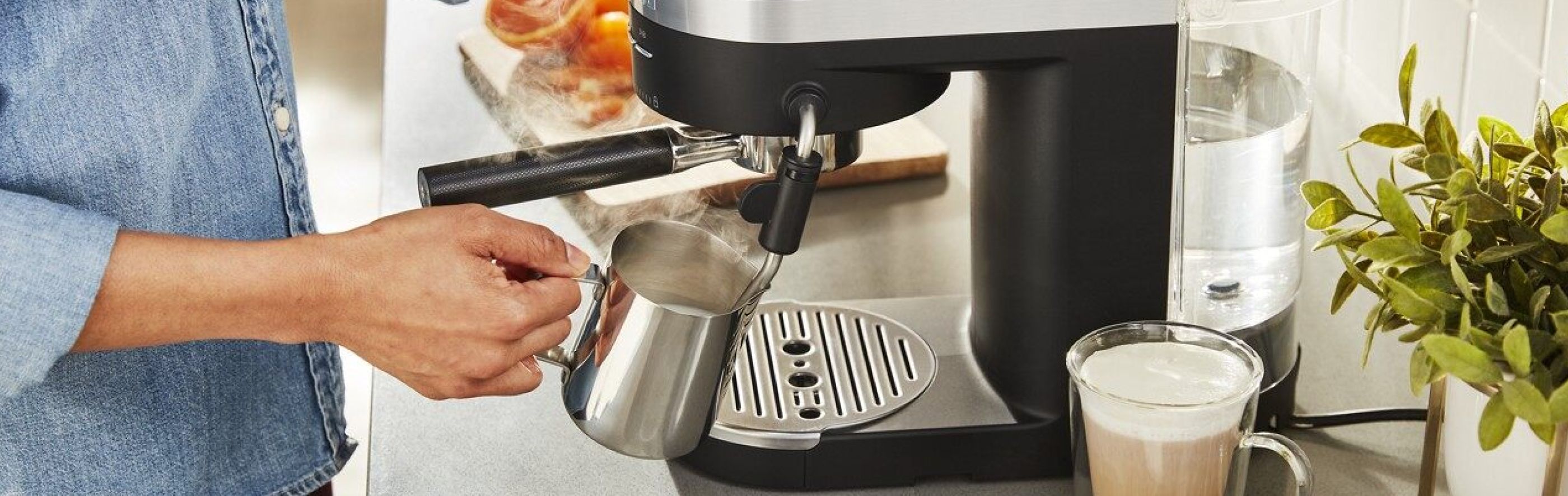 Woman steaming milk with an espresso machine