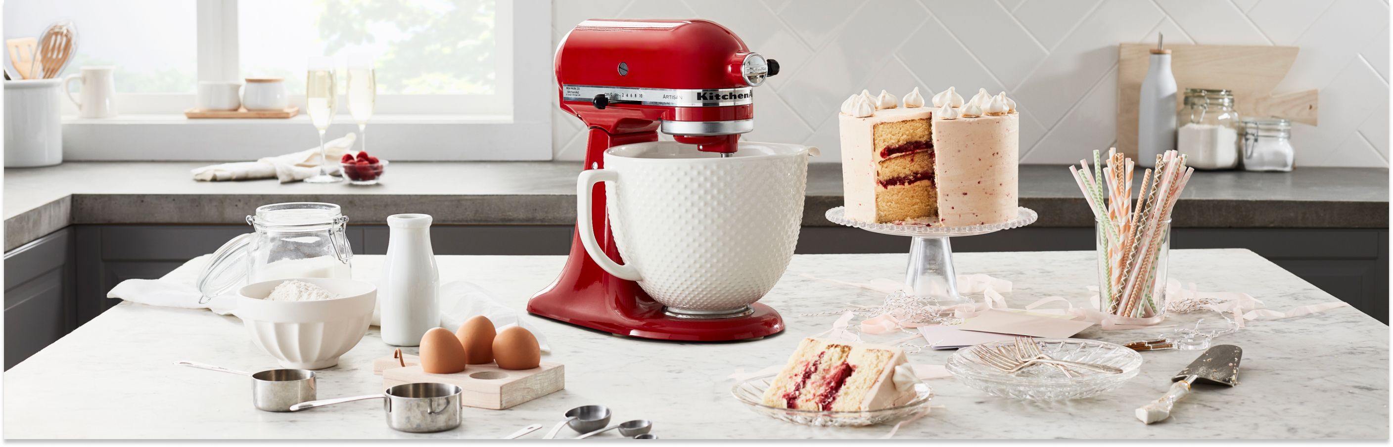 KitchenAid® stand mixer surrounded by layer cake and ingredients for buttercream frosting