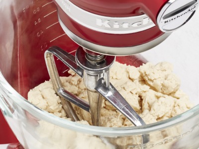 Dough inside the mixing bowl of a red KitchenAid® stand mixer