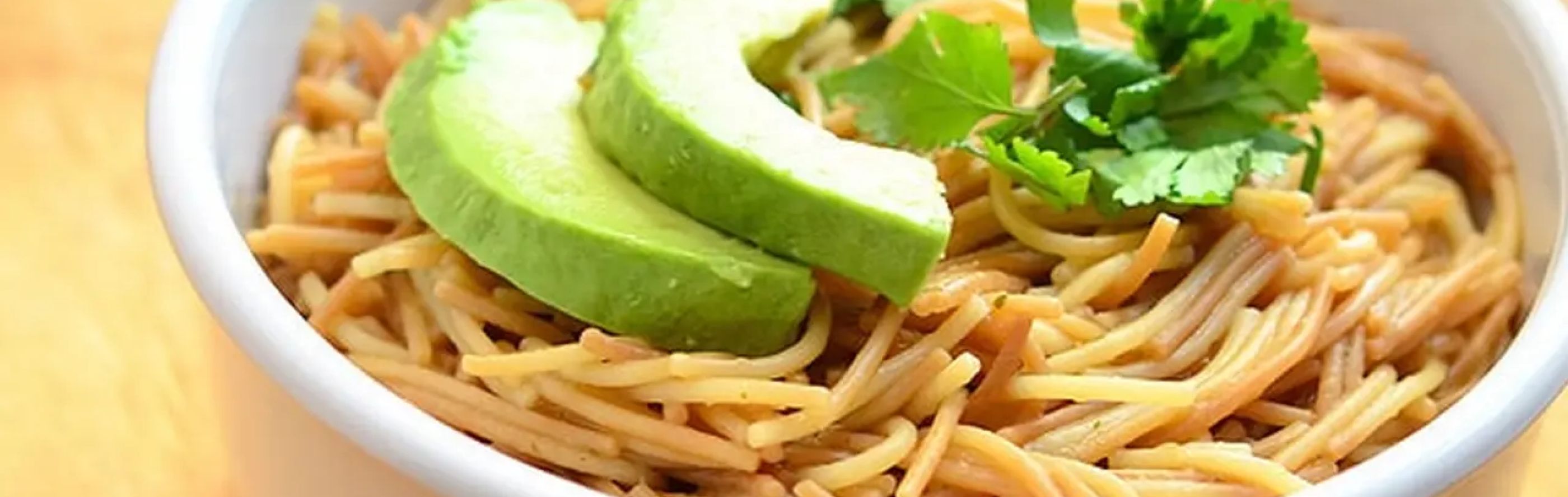Spanish Fideo in a bowl topped with avocado slices
