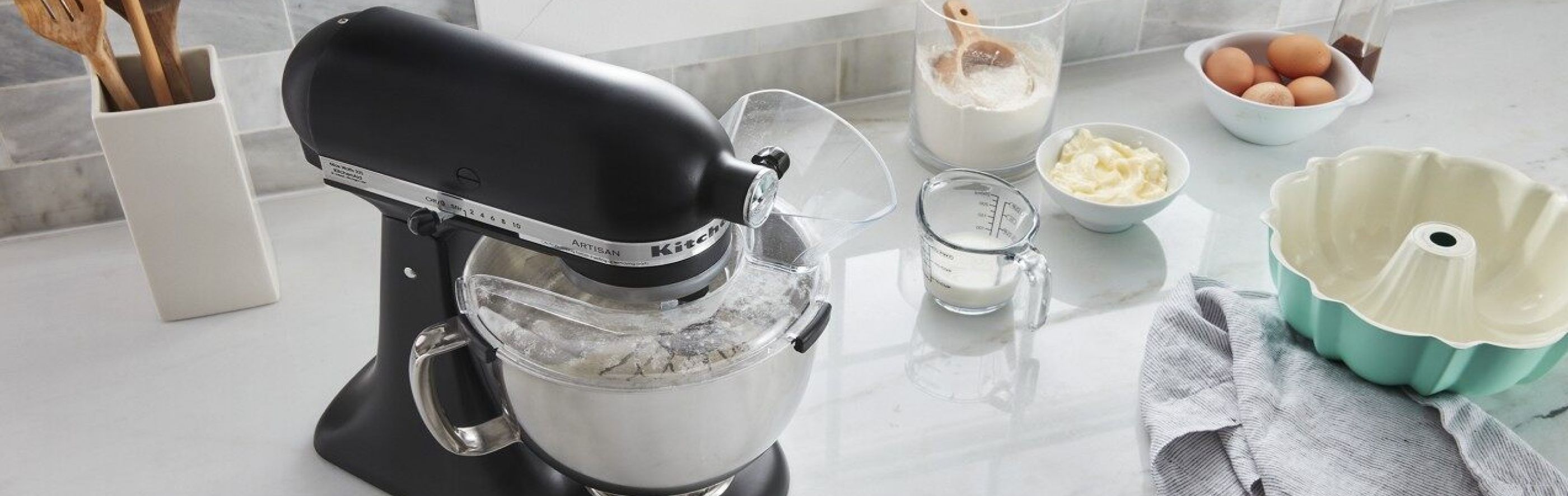 A KitchenAid® stand mixer surrounded by baking ingredients