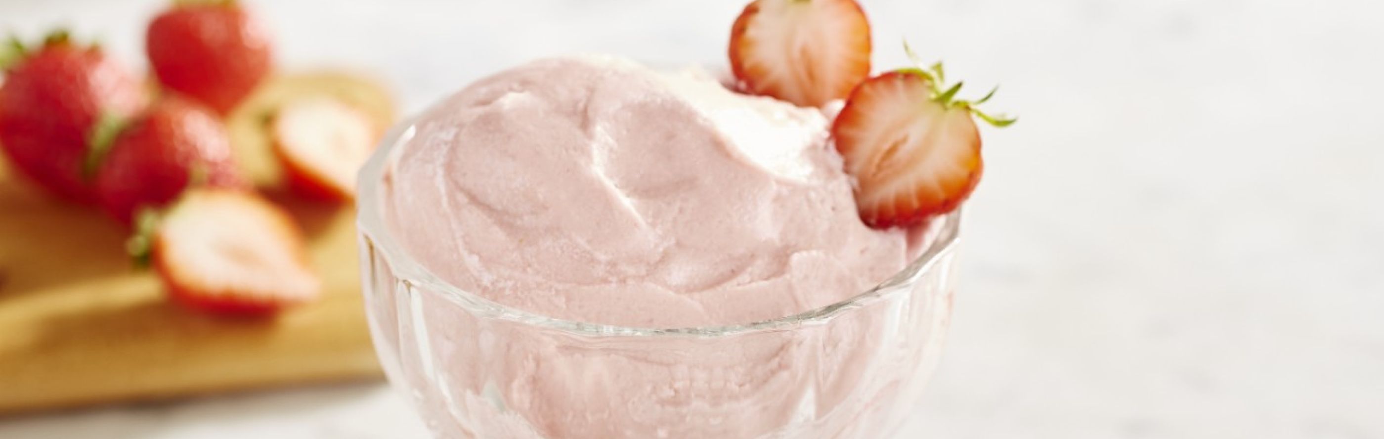 Strawberry ice cream in a glass dish.