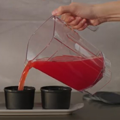 Fruit mixture pouring from a blender into molds