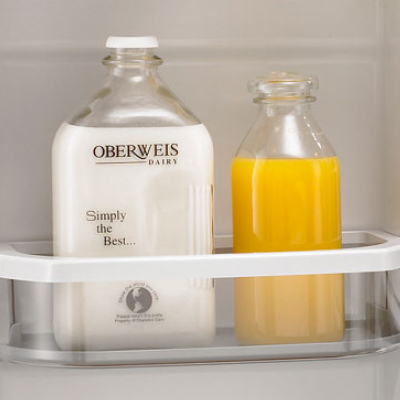 Glass jug of orange juice next to a glass jug of milk