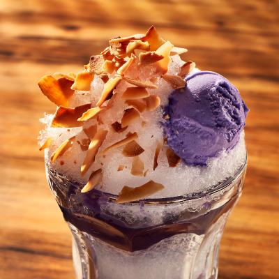 A cup of kakigori topped with purple ice cream.