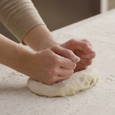 Hands stretching out dough