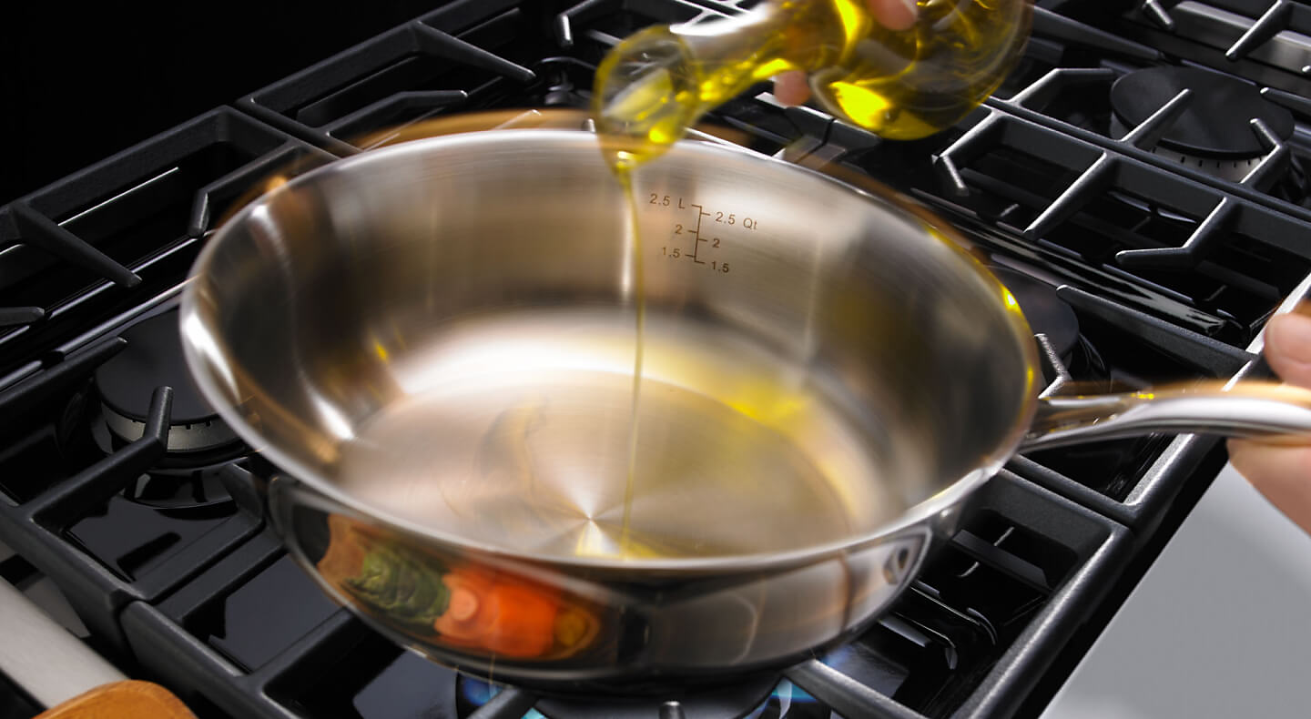 Person pouring oil in a pan