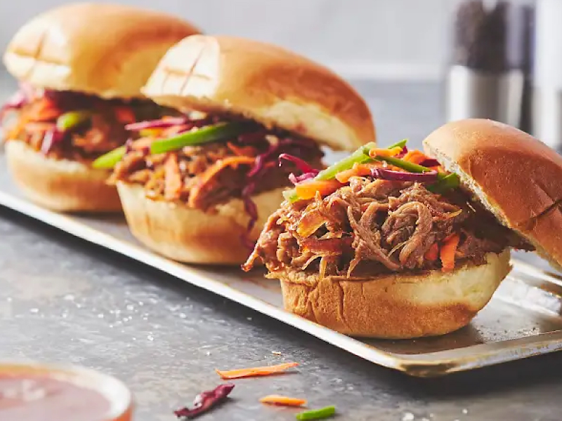 Three pulled pork sandwiches on a plate