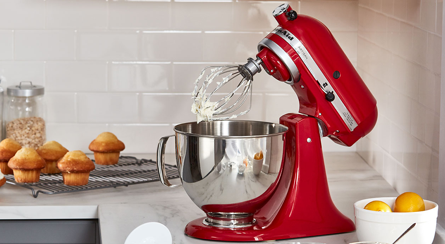 Red KitchenAid® stand mixer with stainless steel bowl and wire whisk attachment