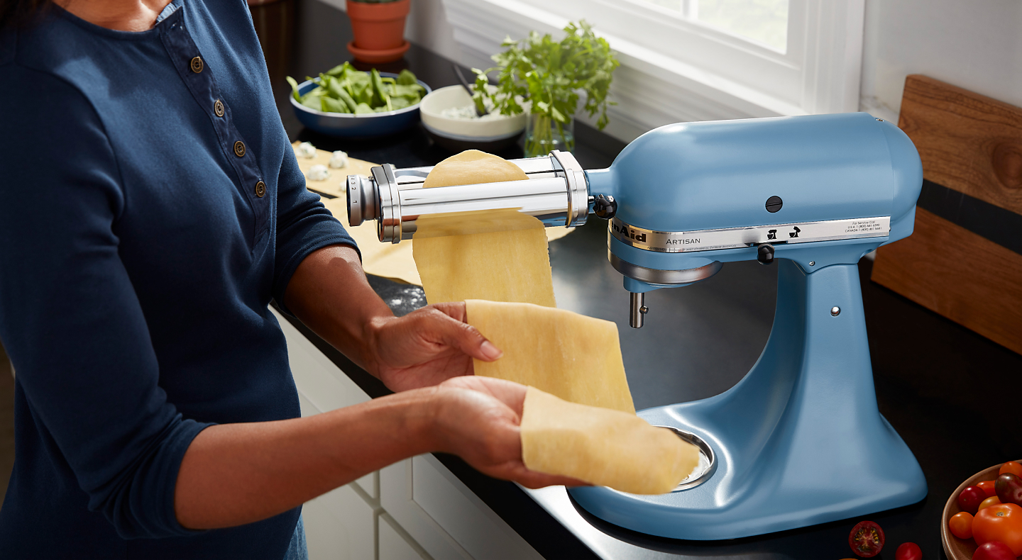 Man rolling pasta dough using the KitchenAid® pasta roller attachment