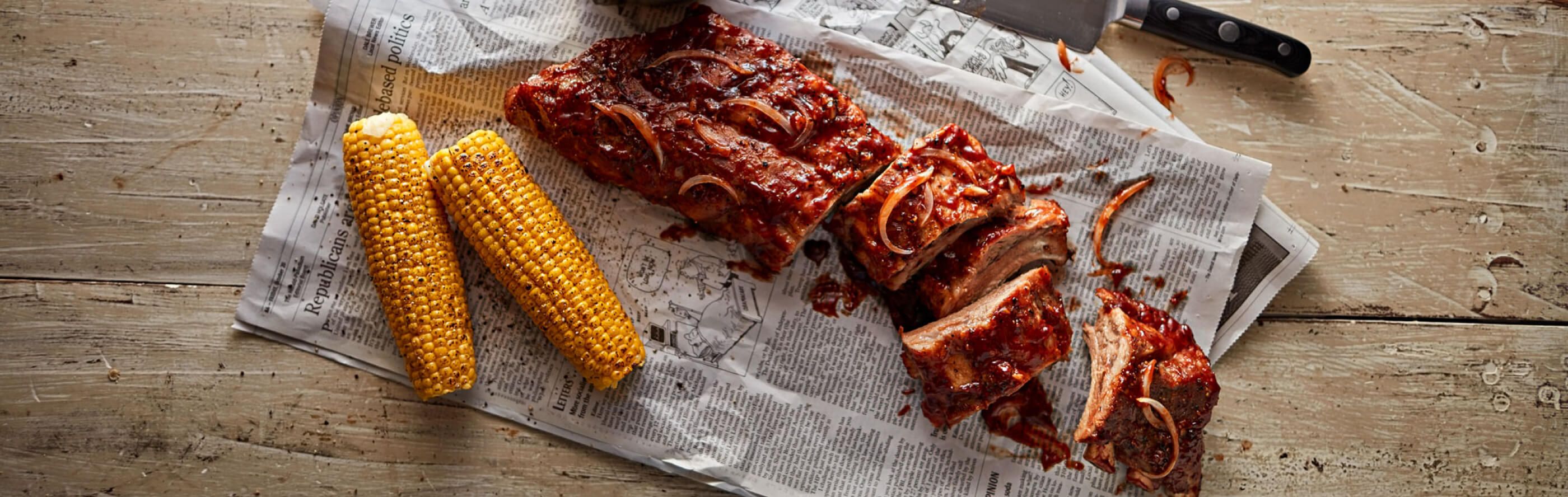 Large rack of ribs next to corn.