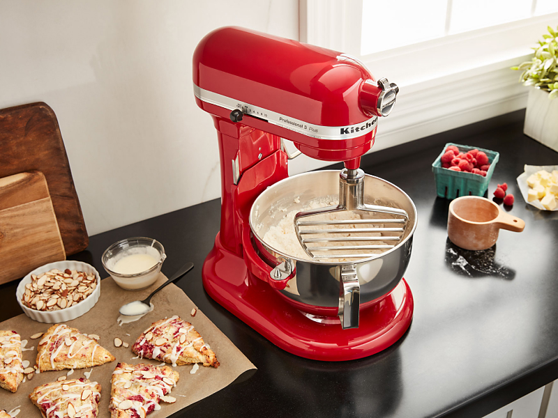 KitchenAid® pastry beater in bowl of  KitchenAid® stand mixer next to homemade scones