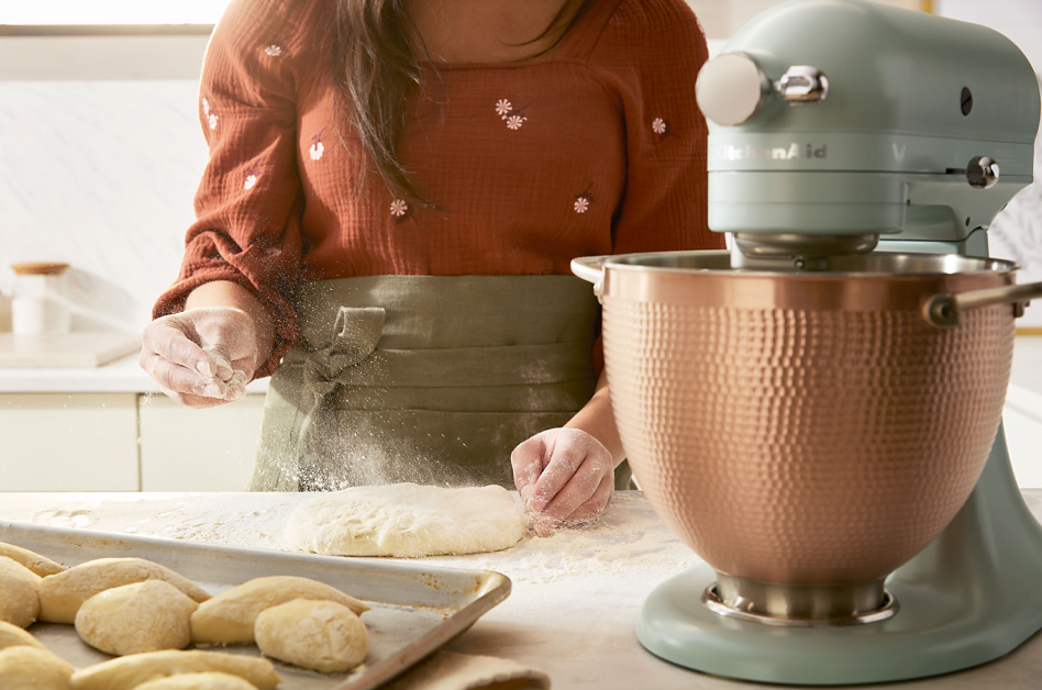 Scone dough being sprinkled with flour next to  KitchenAid® stand mixer