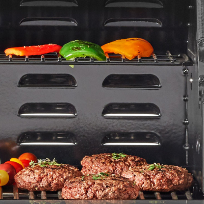 Ground meat patties on grill with grilled peppers