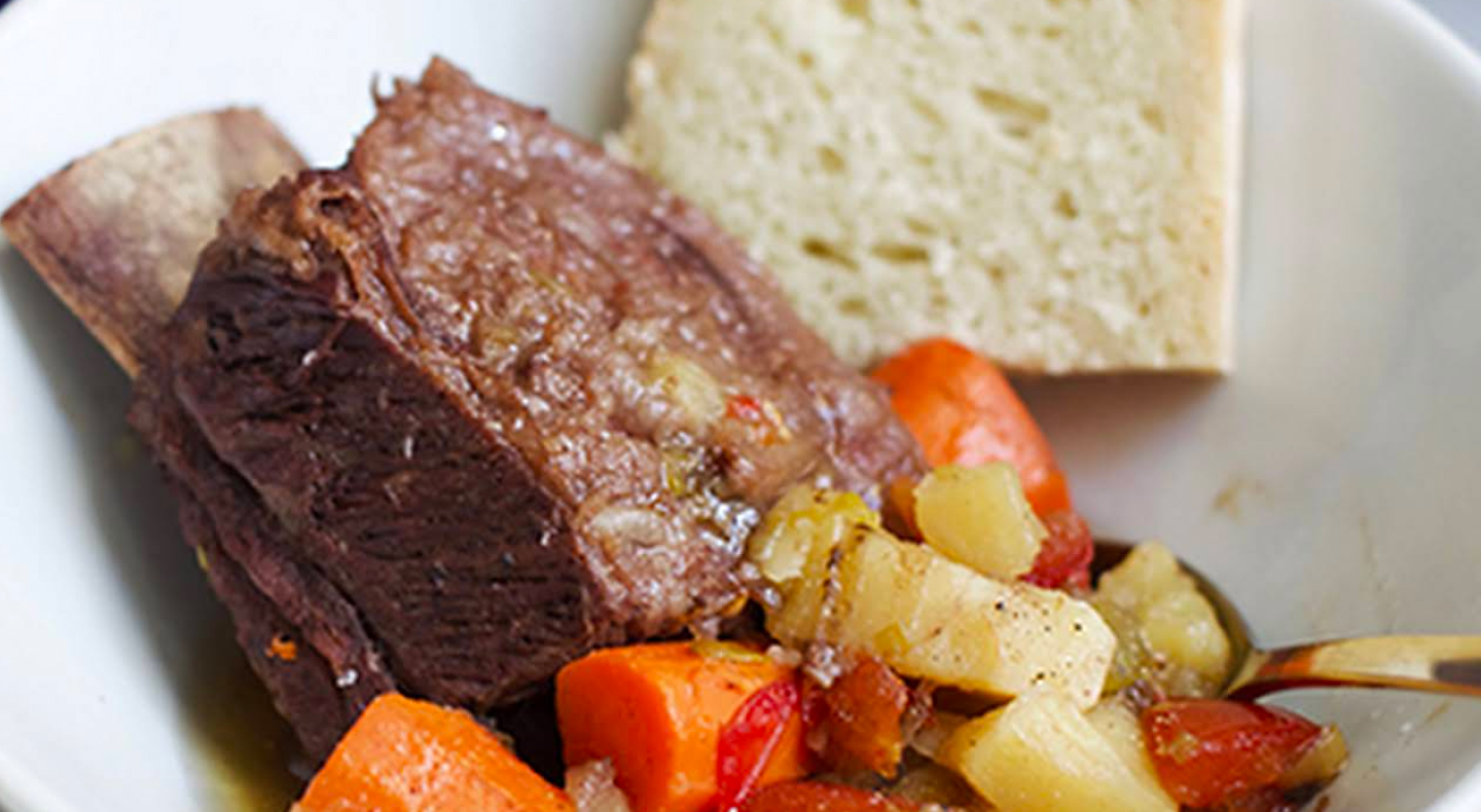 Short ribs with vegetables on plate with bread