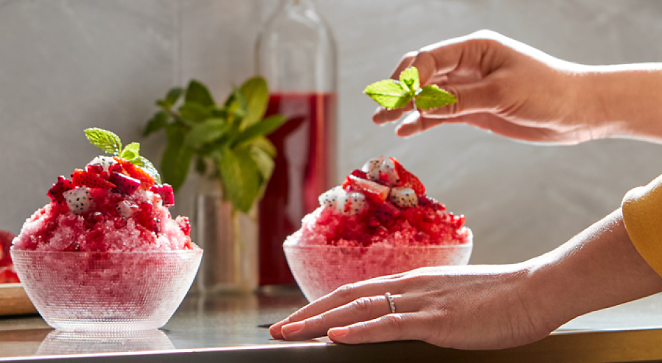 Frozen dessert topped with red sauce, dragon fruit and mint sprig