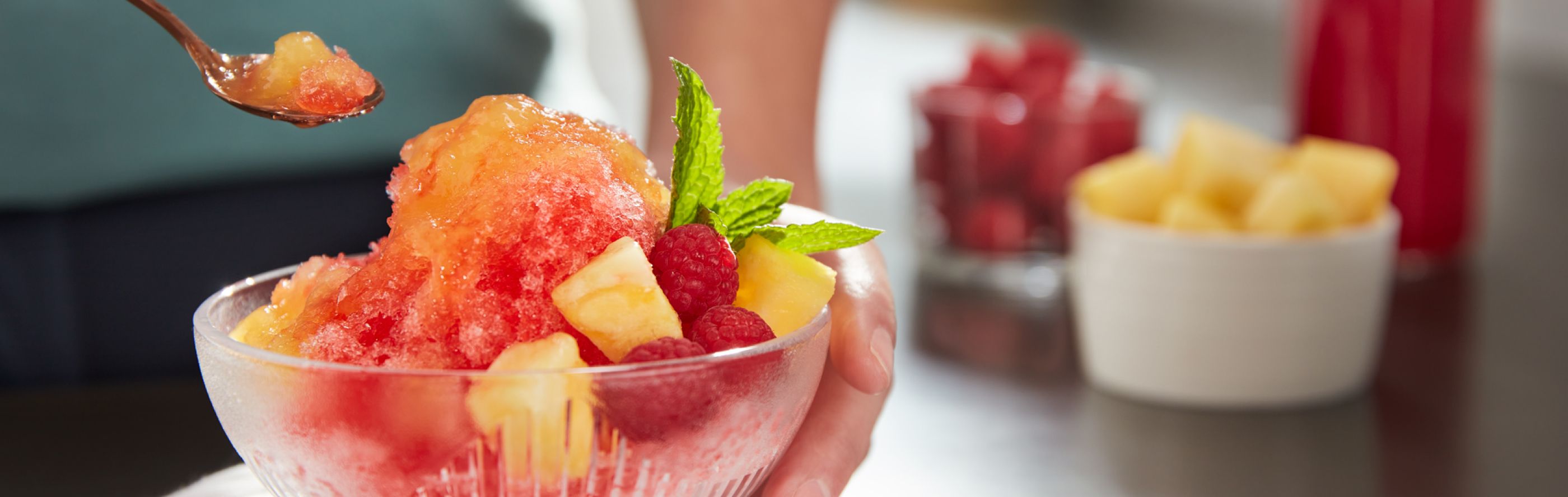 Frozen ice desserts topped with syrup and chopped fruits